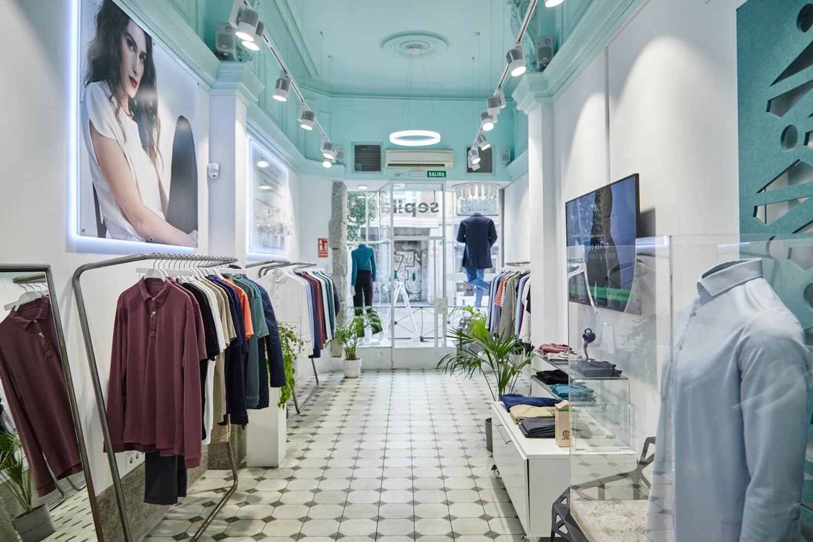 Interior de una tienda Sepiia con perchas de ropa y pantalla informativa